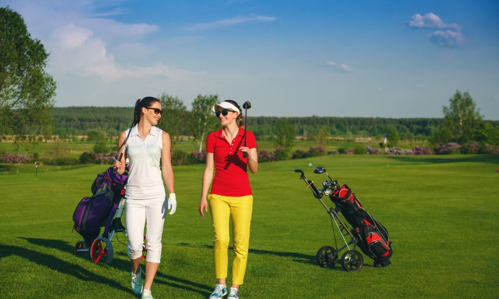 Two ladies wearing golf attire to play golf in the evening