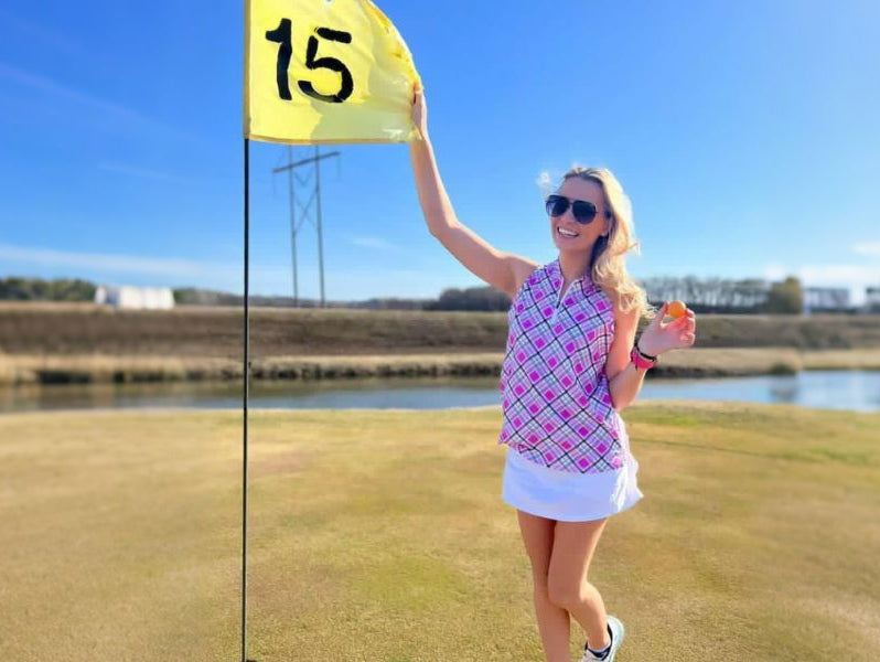 Woman wearing pink and white checkered sleeveless golf shirt