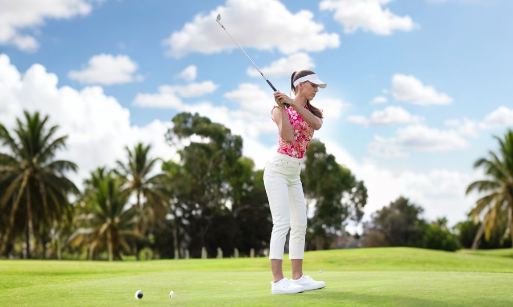 Women wear bright pink sleeveless printed golf shirts to play golf