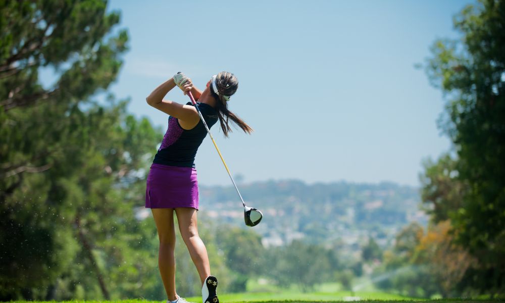Lady finishes golf shot
